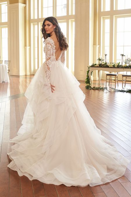 Traje de novia con cuerpo de encaje, escote en la espalda y falda de volantes