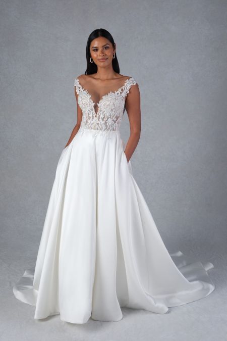 Traje de novia con falda de mikado, cuerpo bordado en pedreria y botonadura en la cola